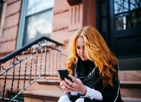woman looking on her phone for short-term rentals