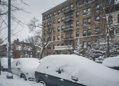 snow covered cars parked along streets in Brooklyn, NY.