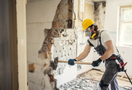 Worker using hammer to demo a wall