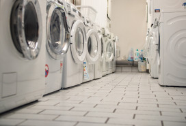 Laundry room of an apartment house in the basement with some washers in a row stock photo