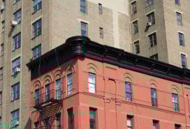 An image of the top of a brick New York City apartment building, including its parapet.
