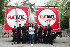 Team members and founder standing in from of two FlatRate Moving trucks
