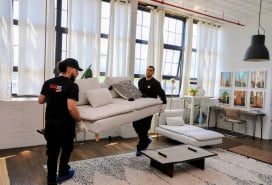 Flat Rate movers in uniform carrying a couch