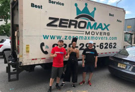 Zero Max Movers standing in front of one of their moving trucks