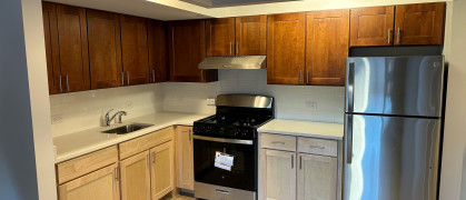 Kitchen with appliances, white countertop and hardwood floors