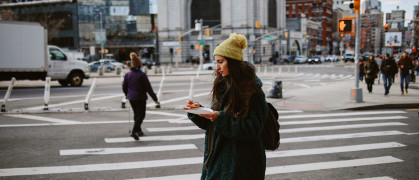 Commuter having a pizza slice on the go in Manhattan, New York.