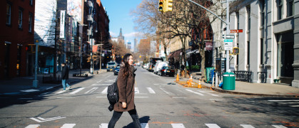 Young woman crossing the street in Manhattan, New York - stock photo