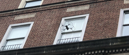 A drone flies toward a building for a facade inspection.