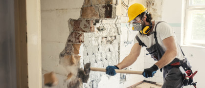 Worker using hammer to demo a wall
