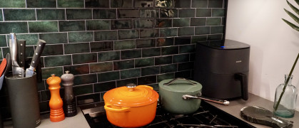 A kitchen backsplash decorated with green tiles.