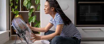 A woman seated in front of a fan.