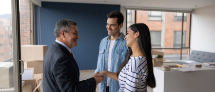 Real Estate Agent selling an apartment to a couple and closing the deal with a handshake stock photo