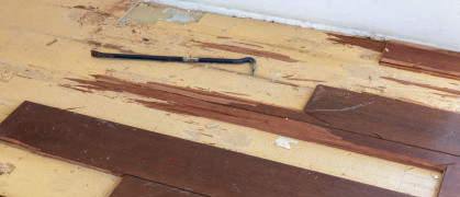 Wood floor partially removed with a tool for levering planks