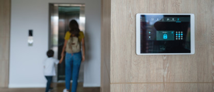 Mother and son leaving the house and locking the door using an automated security system