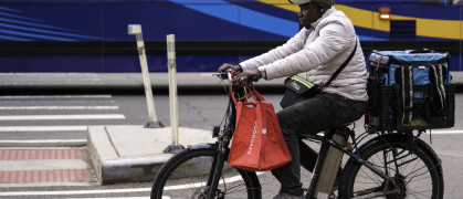 A delivery person on an e-bike rides on Second Avenue in Manhattan.