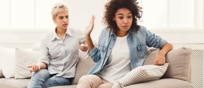 Roommates seated on a couch having an argument