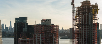Modern buildings under construction on the waterfront in Greenpoint, Brooklyn with the view of Manhattan with Freedom Tower over the East River.