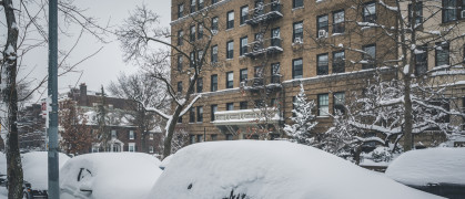snow covered cars parked along streets in Brooklyn, NY.