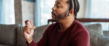 Man at home using inhaler