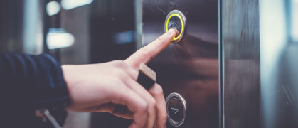 Hand pushing elevator buttons.