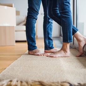 couple standing close, only jeans-clad legs showing