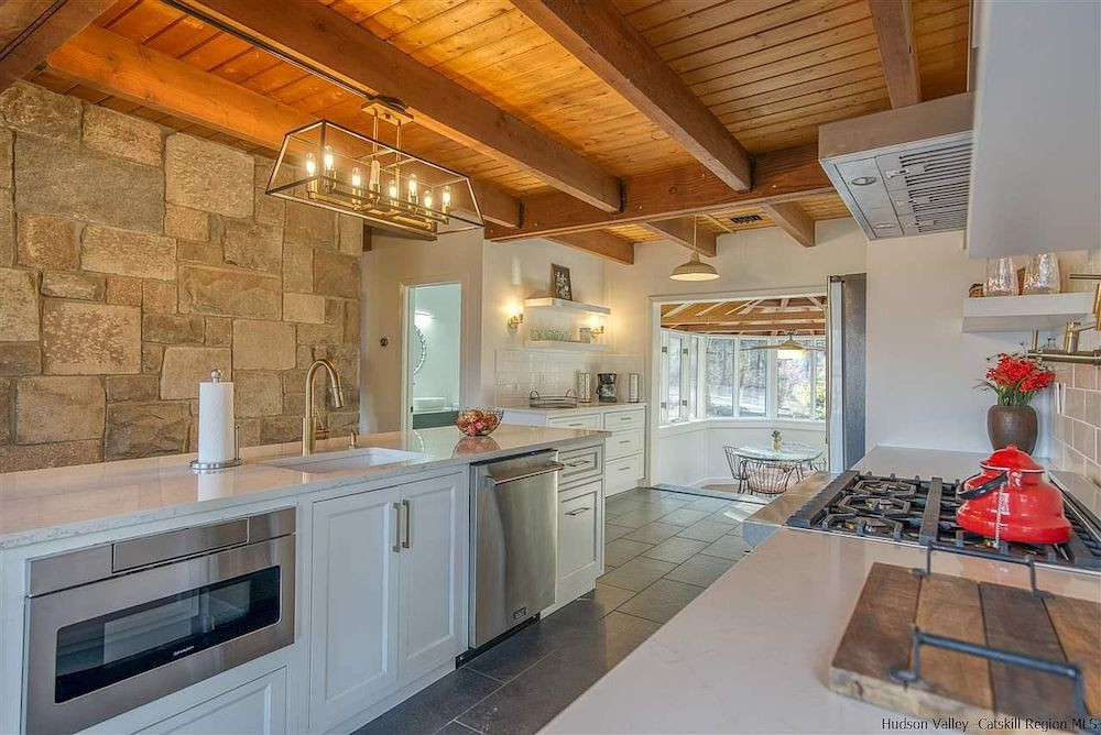 A house in Woodstock, NY, with a stone tower and mountain views, for