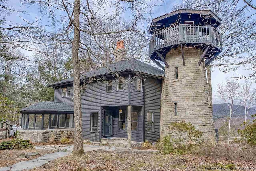 A house in Woodstock, NY, with a stone tower and mountain views, for